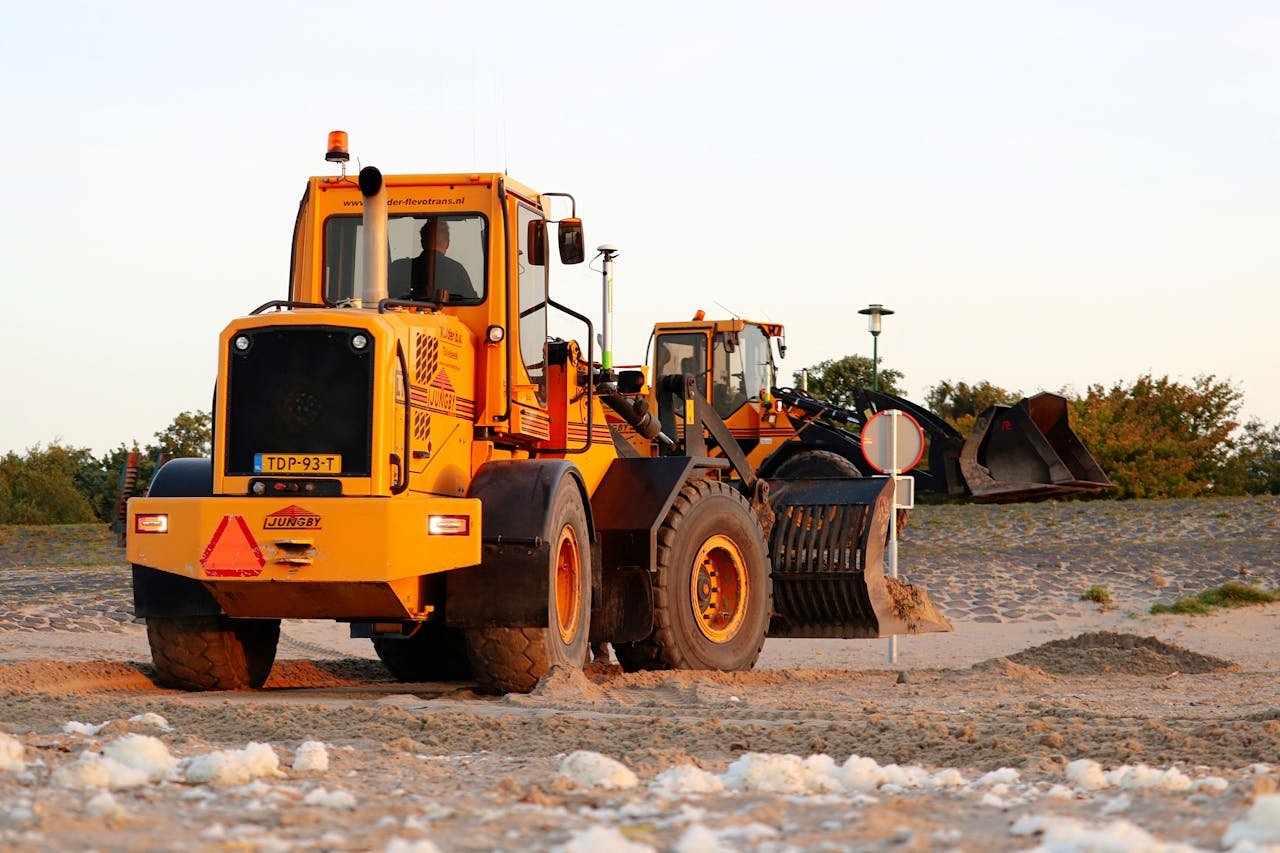Yellow bulldozer working on sandy terrain, illustrating heavy machinery in action outdoors.